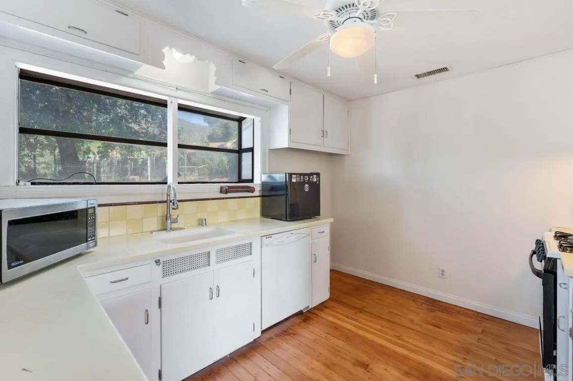 155 Willowside Terrace Alpine, CA 91901 - Photo 11 of 38 a kitchen with a sink cabinets and wooden floor