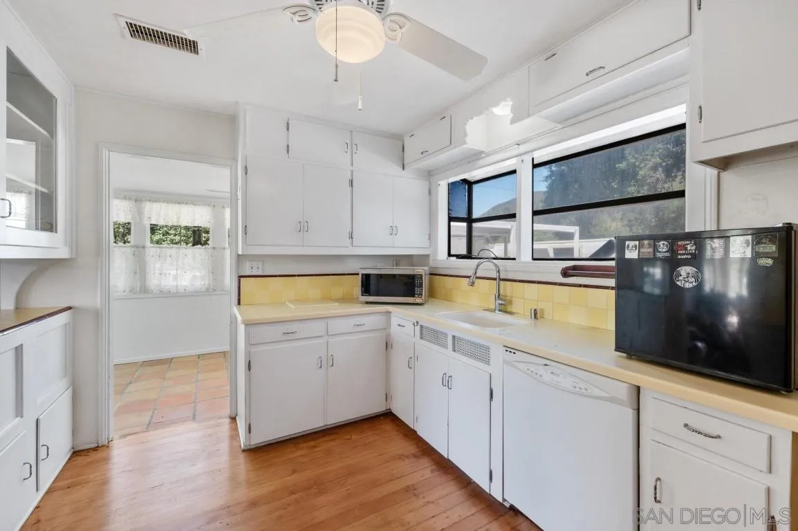 155 Willowside Terrace Alpine, CA 91901 - Photo 12 of 38 a open kitchen with stainless steel appliances granite countertop a stove a sink and white cabinets with wooden floor