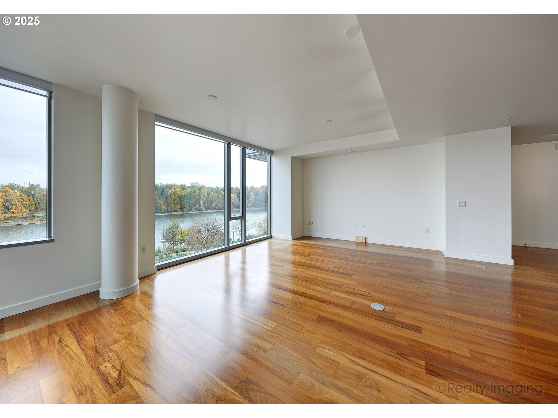 841 Southwest Gaines Street, Unit 319 Portland, OR 97239 - Photo 5 of 44 a view of an empty room with wooden floor and a window