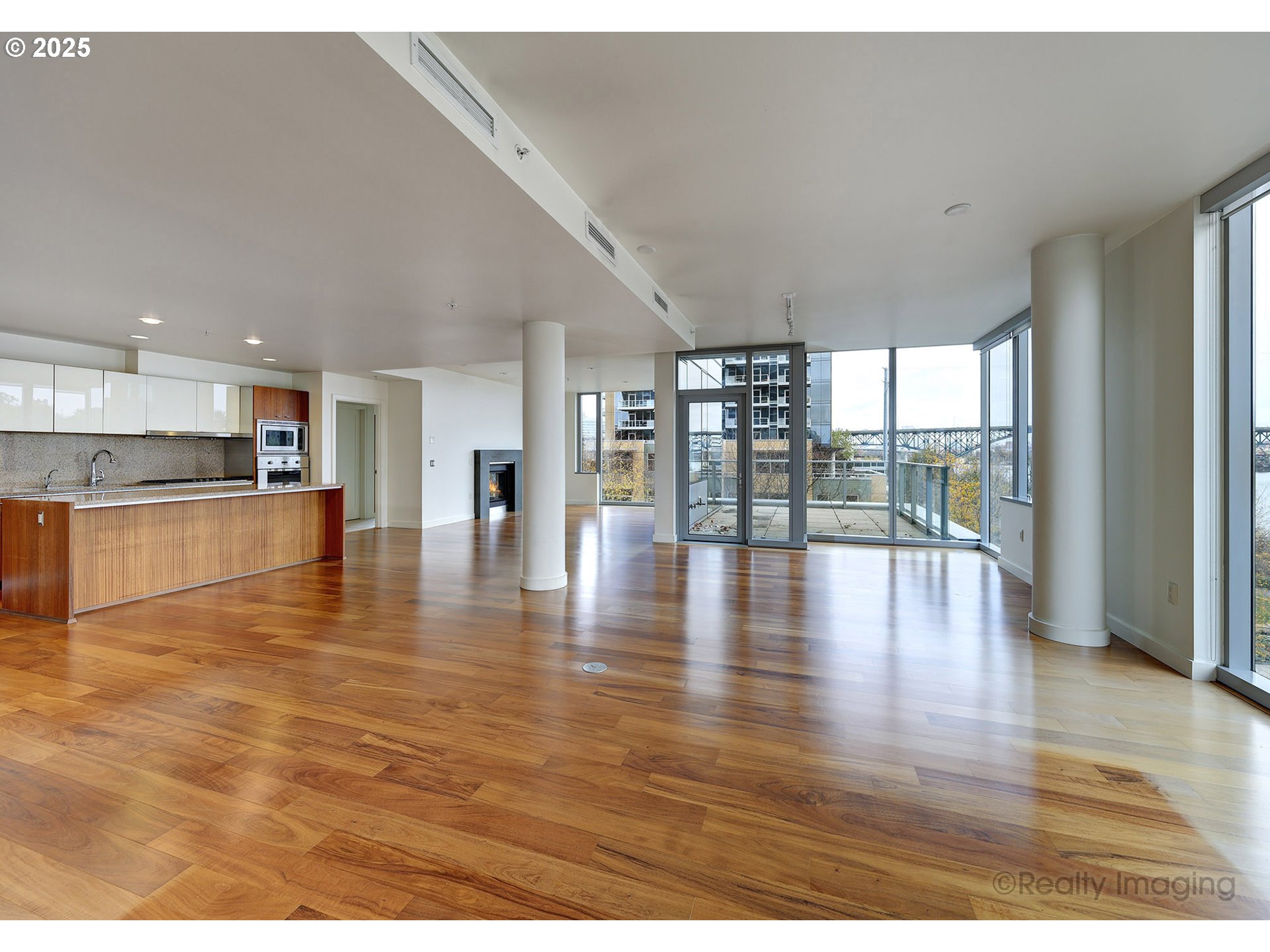 841 Southwest Gaines Street, Unit 319 Portland, OR 97239 - Photo 6 of 44 a view of an empty room with wooden floor and a kitchen