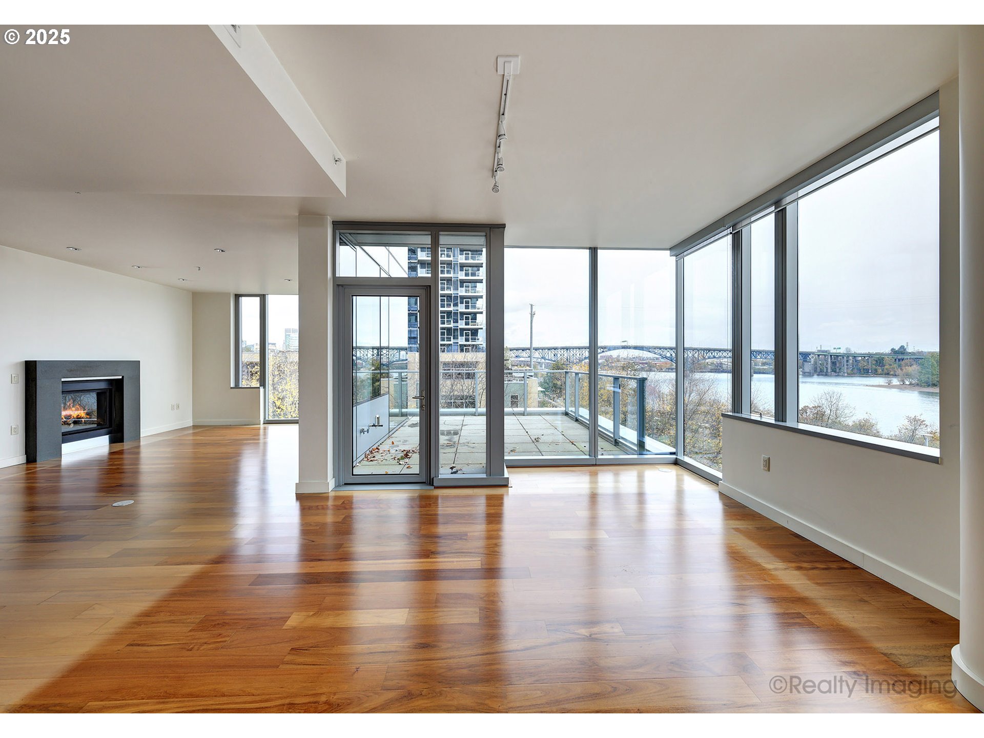 841 Southwest Gaines Street, Unit 319 Portland, OR 97239 - Photo 7 of 44 a view of an empty room with wooden floor and a window