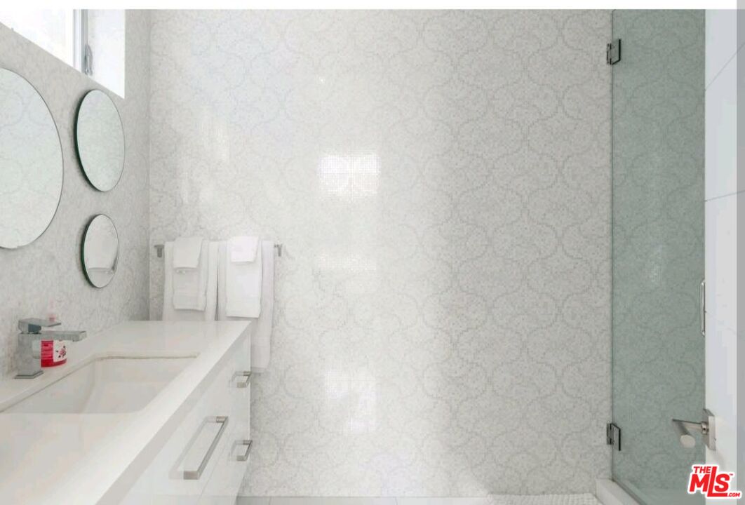 6620 West 5th Street Los Angeles, CA 90048 - Photo 27 of 34 a bathroom with a granite countertop sink a toilet and a shower