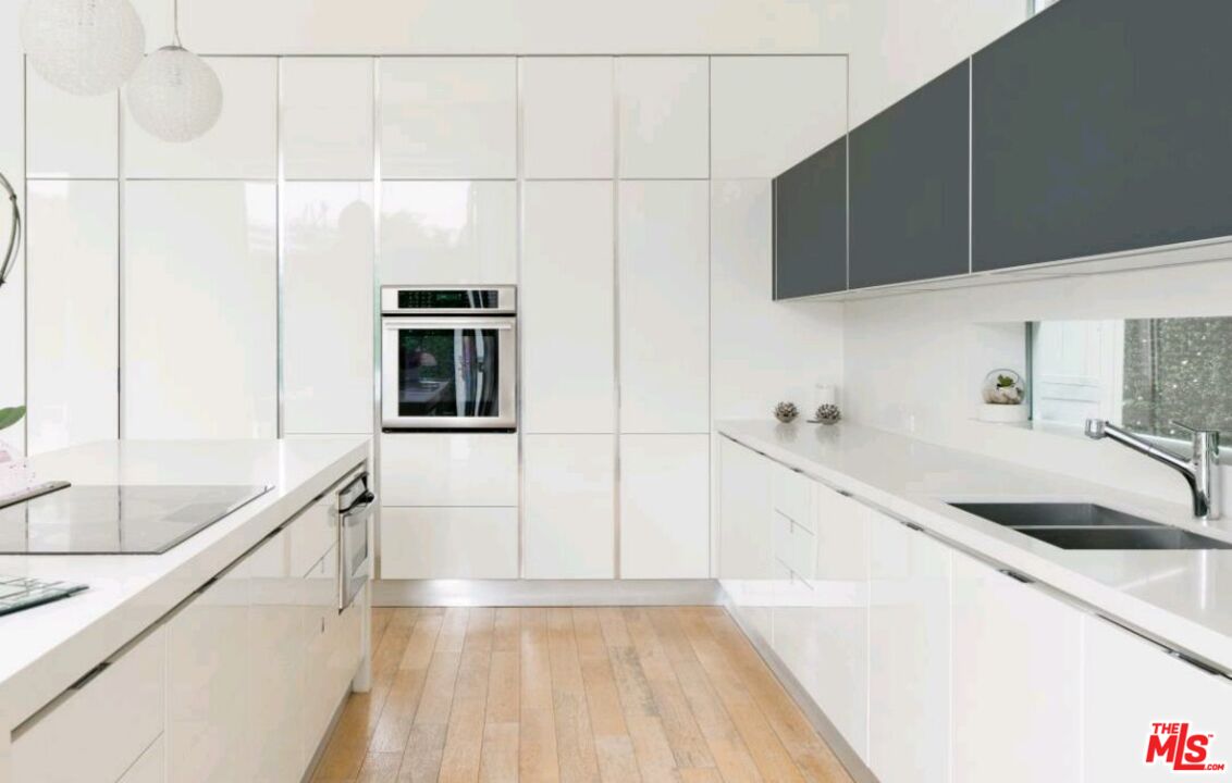 6620 West 5th Street Los Angeles, CA 90048 - Photo 8 of 34 a kitchen with granite countertop a sink and a stove top oven