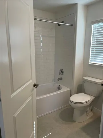 a white toilet sitting next to a bath tub