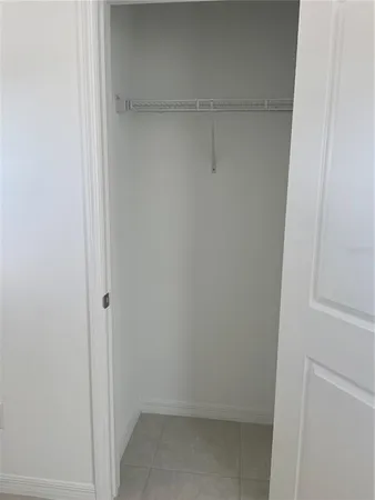 a kitchen with granite countertop a stove a sink and white cabinets