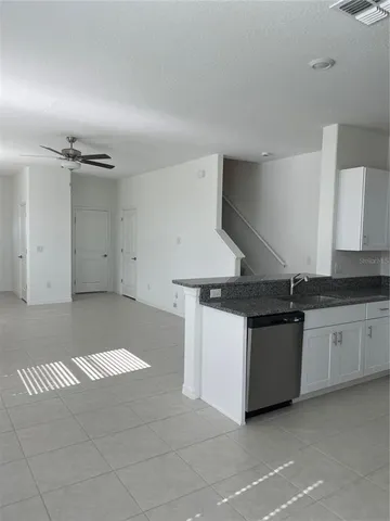 a kitchen with granite countertop a sink and a stove