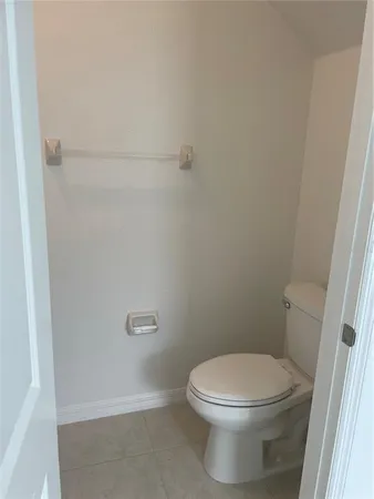 a white toilet sitting next to a shower