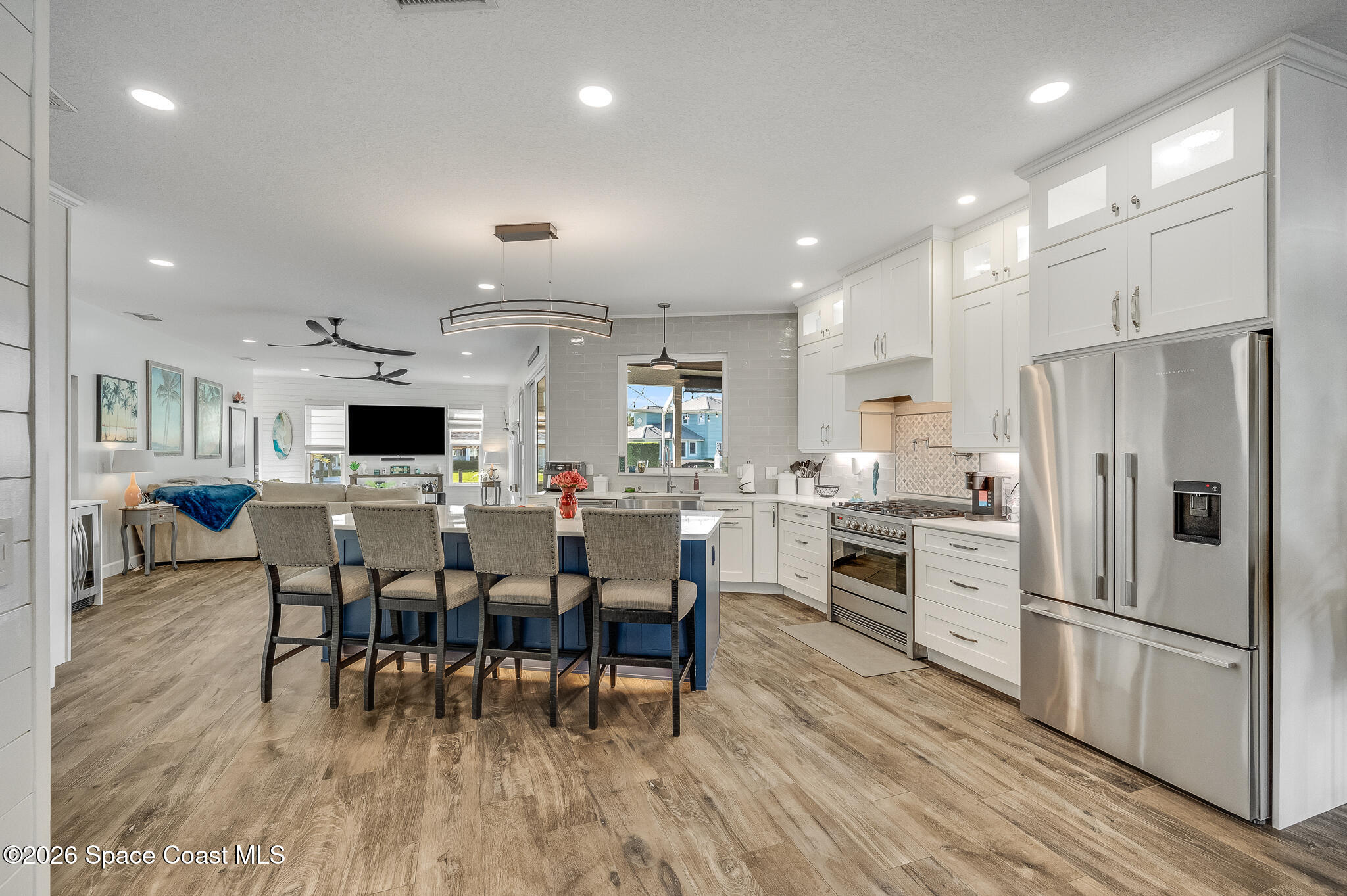 447 Sandy Key Melbourne Beach, FL 32951 - Photo 22 of 94 a kitchen with stainless steel appliances a dining table chairs refrigerator and sink
