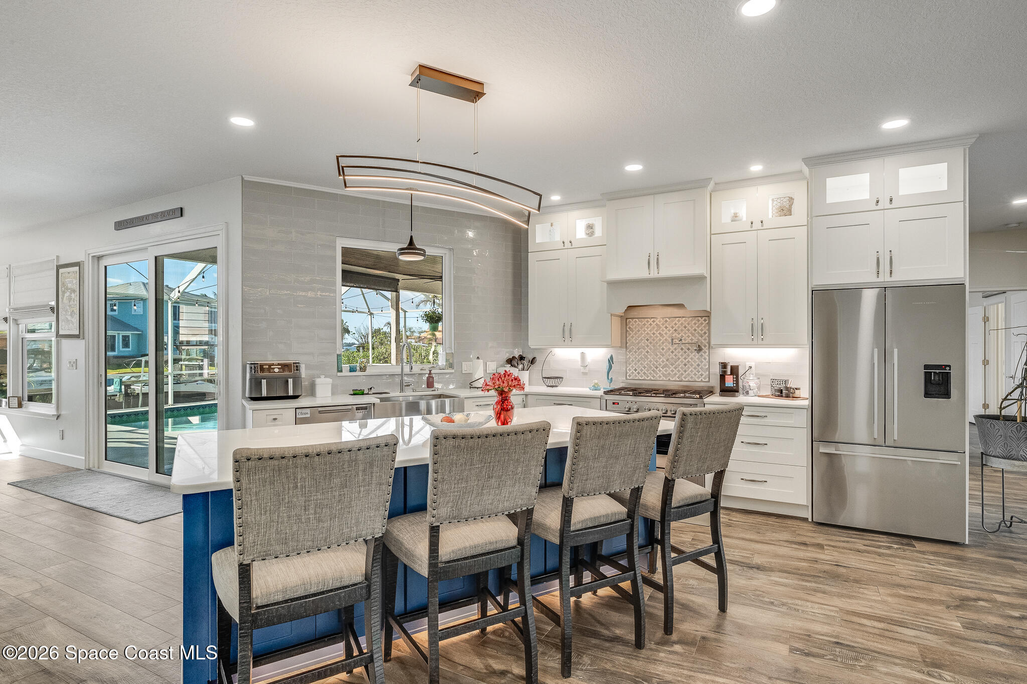 447 Sandy Key Melbourne Beach, FL 32951 - Photo 23 of 94 a dining room with stainless steel appliances kitchen island granite countertop a dining table chairs and a refrigerator