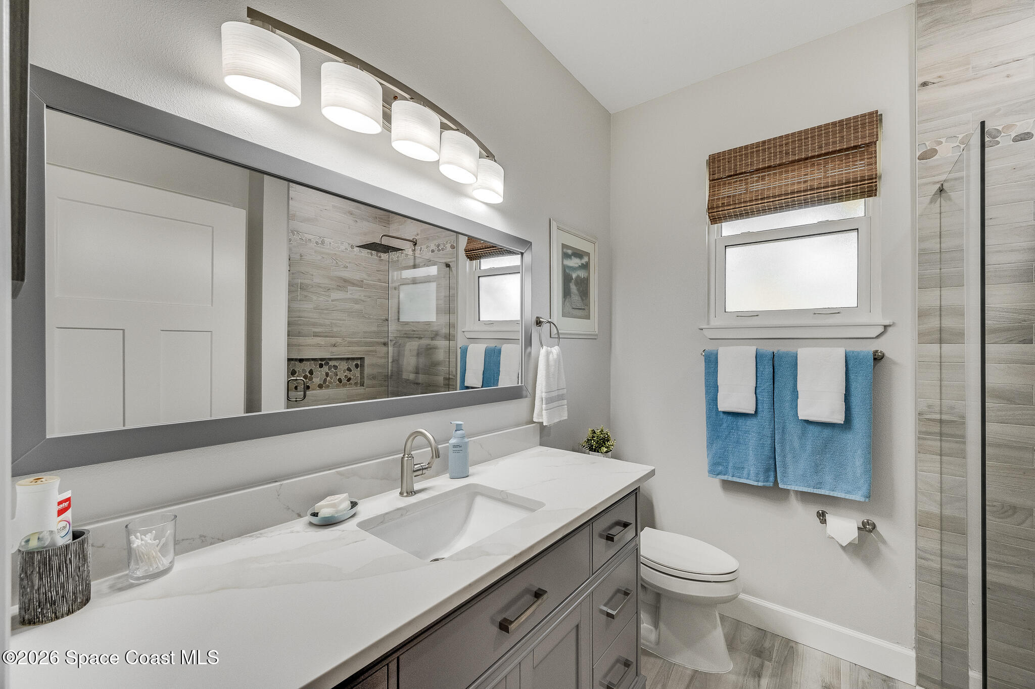 447 Sandy Key Melbourne Beach, FL 32951 - Photo 55 of 94 a bathroom with a granite countertop sink mirror vanity and toilet