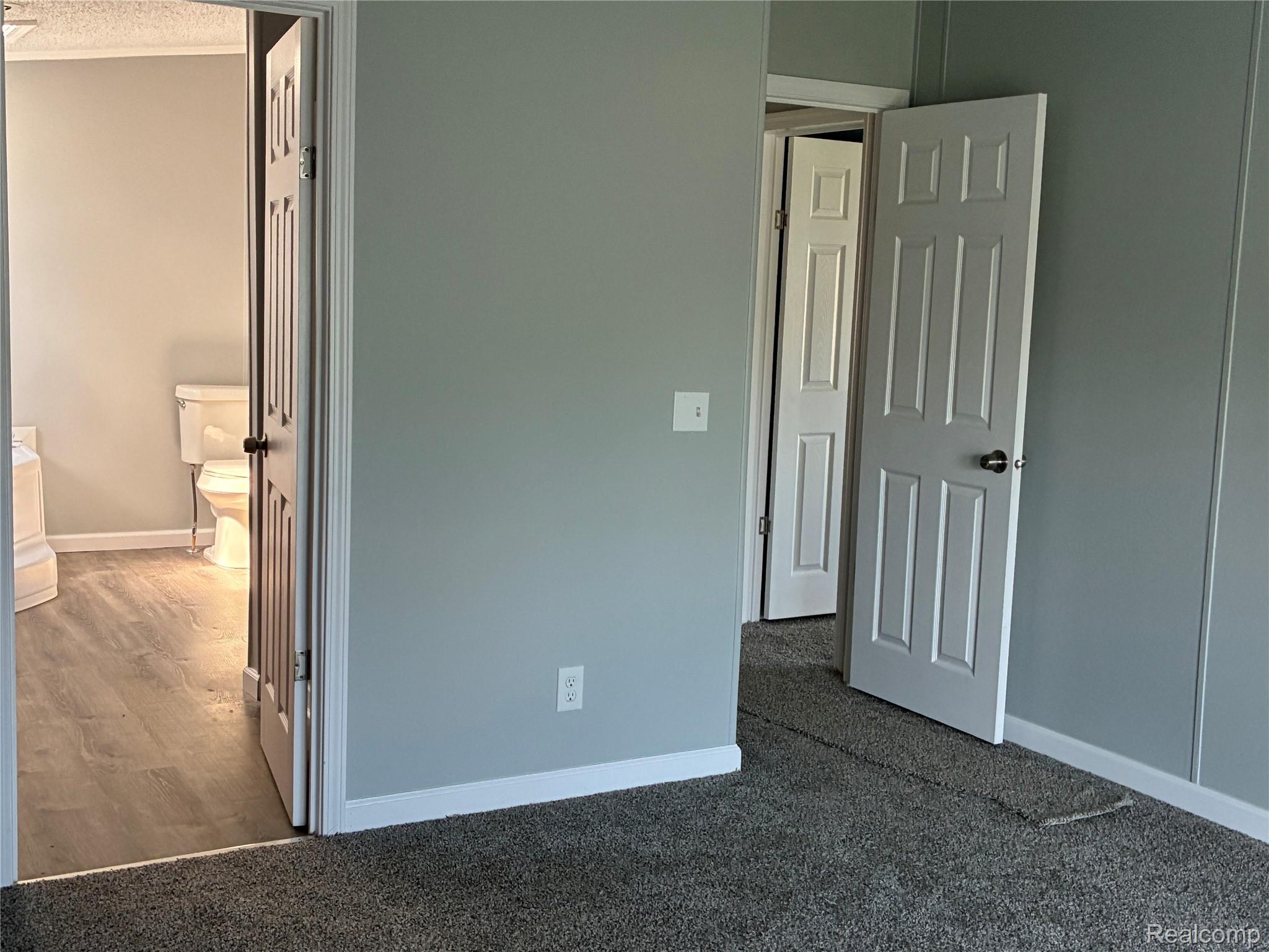 420 Hidden Ridge Road Morrice, MI 48857 - Photo 14 of 16 Unfurnished bedroom with dark carpet and ornamental molding