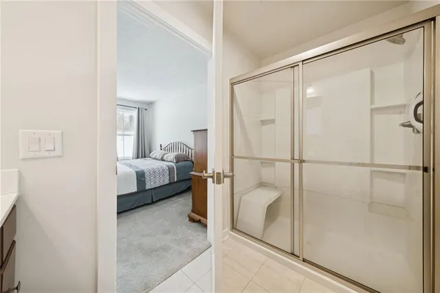 a en suite bathroom with a glass shower door and a sink