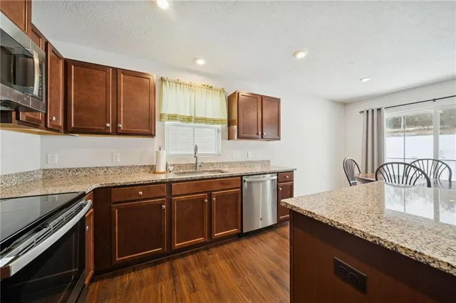 a kitchen with stainless steel appliances granite countertop a sink stove and cabinets