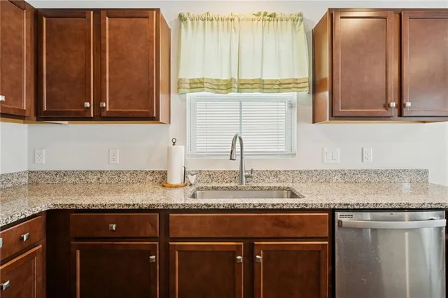 a kitchen with granite countertop a sink and a wooden cabinets
