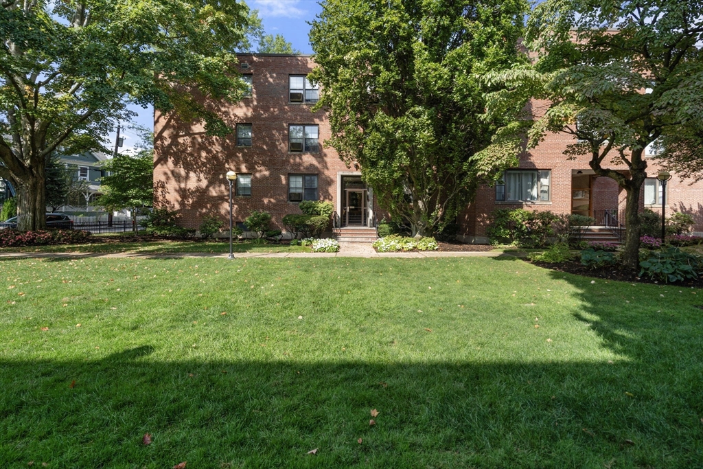 a view of a house with a big yard and large trees