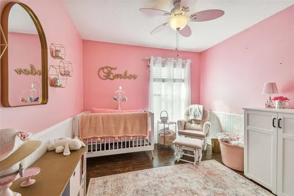 a bedroom with a large bed and wooden floor