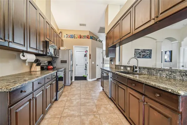 a kitchen with granite countertop stainless steel appliances a sink and cabinets