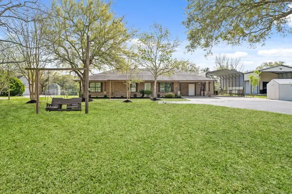 a front view of a house with a garden and trees