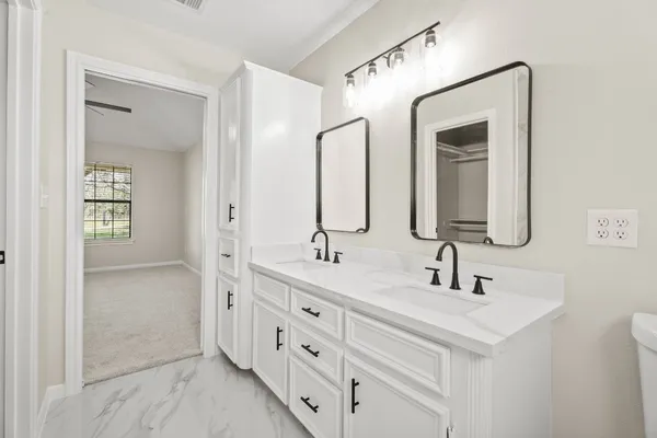 a bathroom with double vanity sink two mirror and a vanity