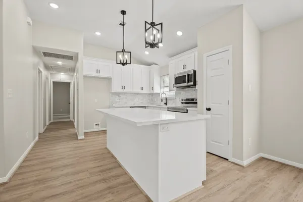 a kitchen with kitchen island a sink and a stove top oven