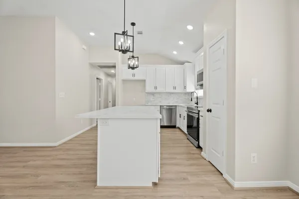 a kitchen with kitchen island a sink stainless steel appliances and cabinets