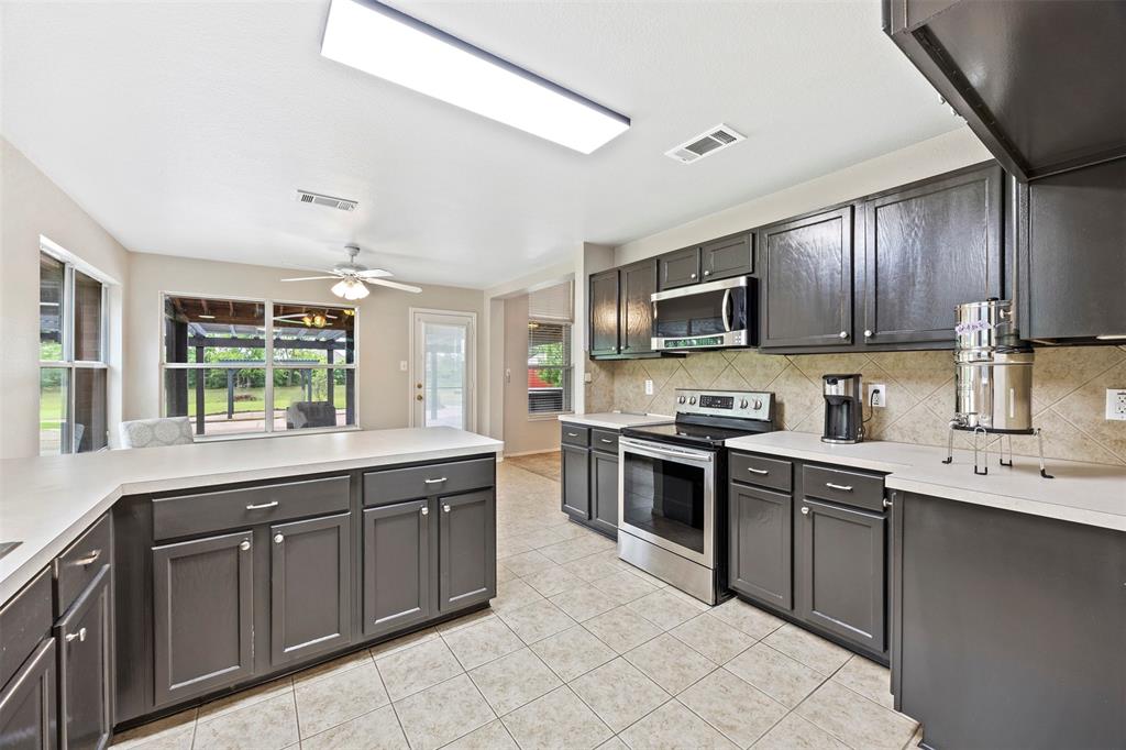 3931 Alpha Way Midlothian, TX 76065 - Photo 15 of 33 a kitchen with stainless steel appliances granite countertop a stove sink and cabinets