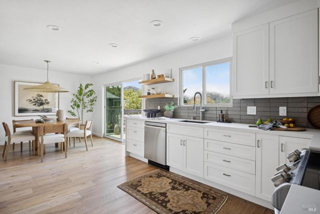 a kitchen with white cabinets and sink