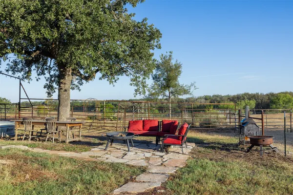 an outdoor sitting area with couch and wooden fence