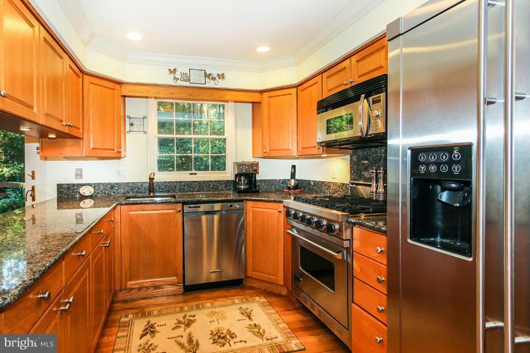 2600 Penny Royal Lane Reston, VA 20191 - Photo 16 of 30 a kitchen with stainless steel appliances granite countertop a stove a sink and a refrigerator