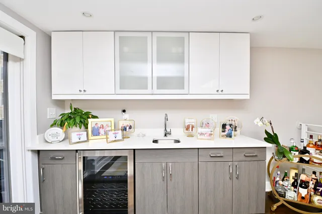a kitchen with white cabinets and wooden floor
