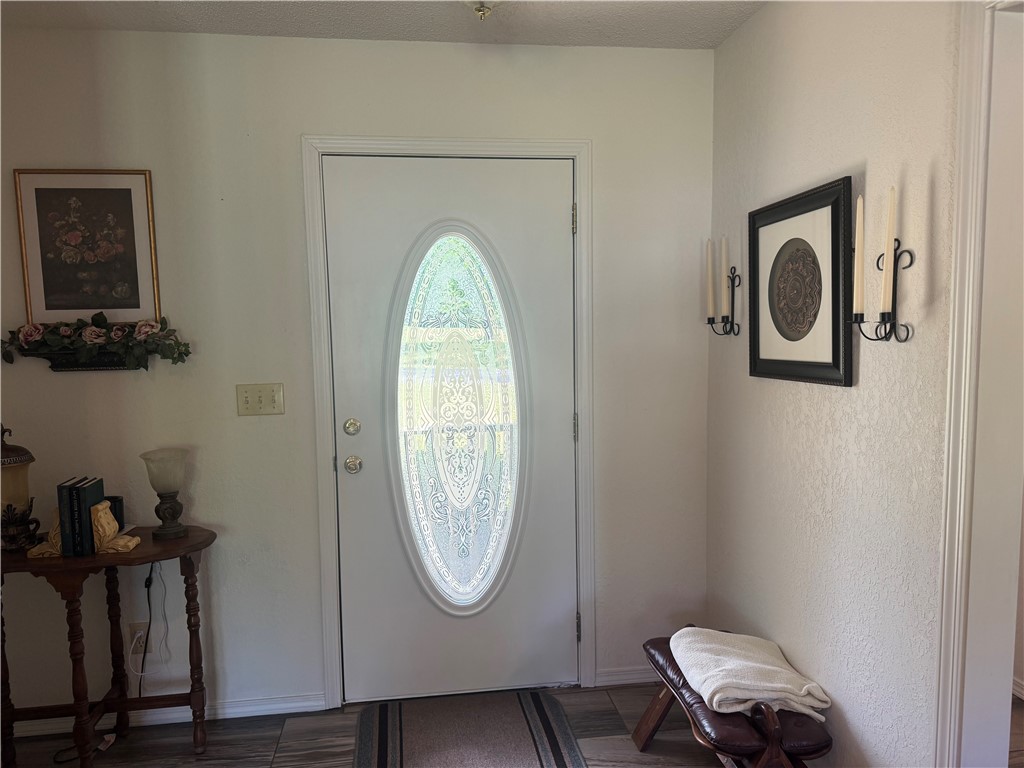 95 Deer Run Road Delaware, AR 72835 - Photo 14 of 40 Entryway featuring a white door with an oval-shaped decorative glass insert, wood-finish flooring, and light-toned walls