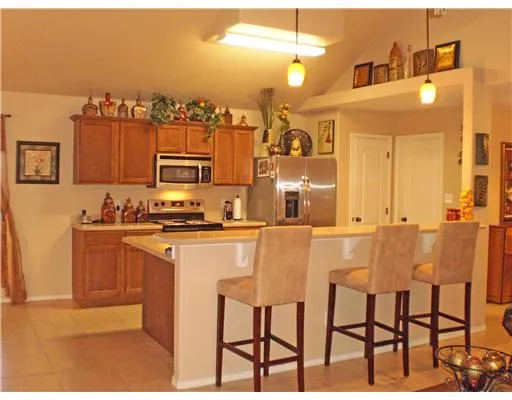 a kitchen with stainless steel appliances granite countertop a sink and a refrigerator