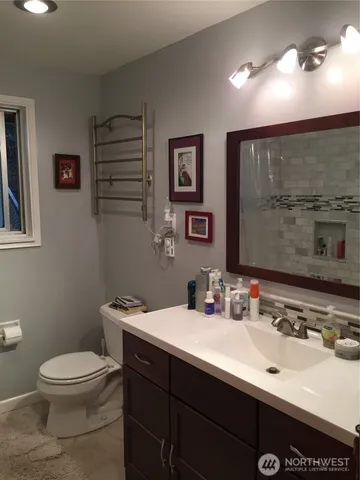a bathroom with a toilet a sink and mirror