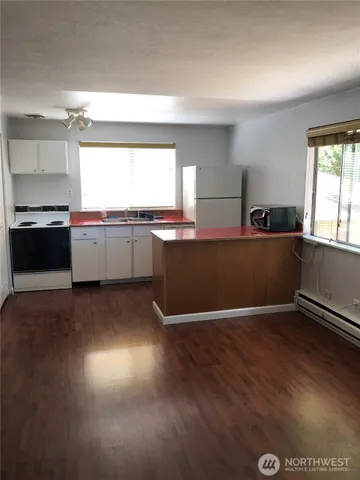 a kitchen with granite countertop a stove and wooden floor