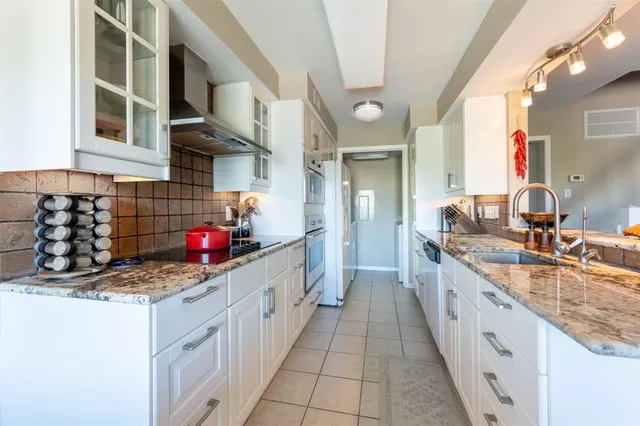a kitchen with stainless steel appliances granite countertop a sink stove and cabinets