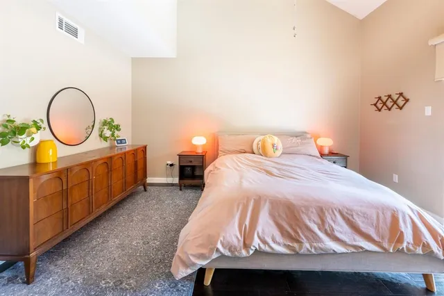 a bedroom with bed and a painting on the wall