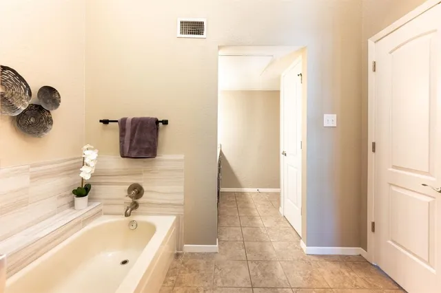 a bathroom with a tub sink and mirror