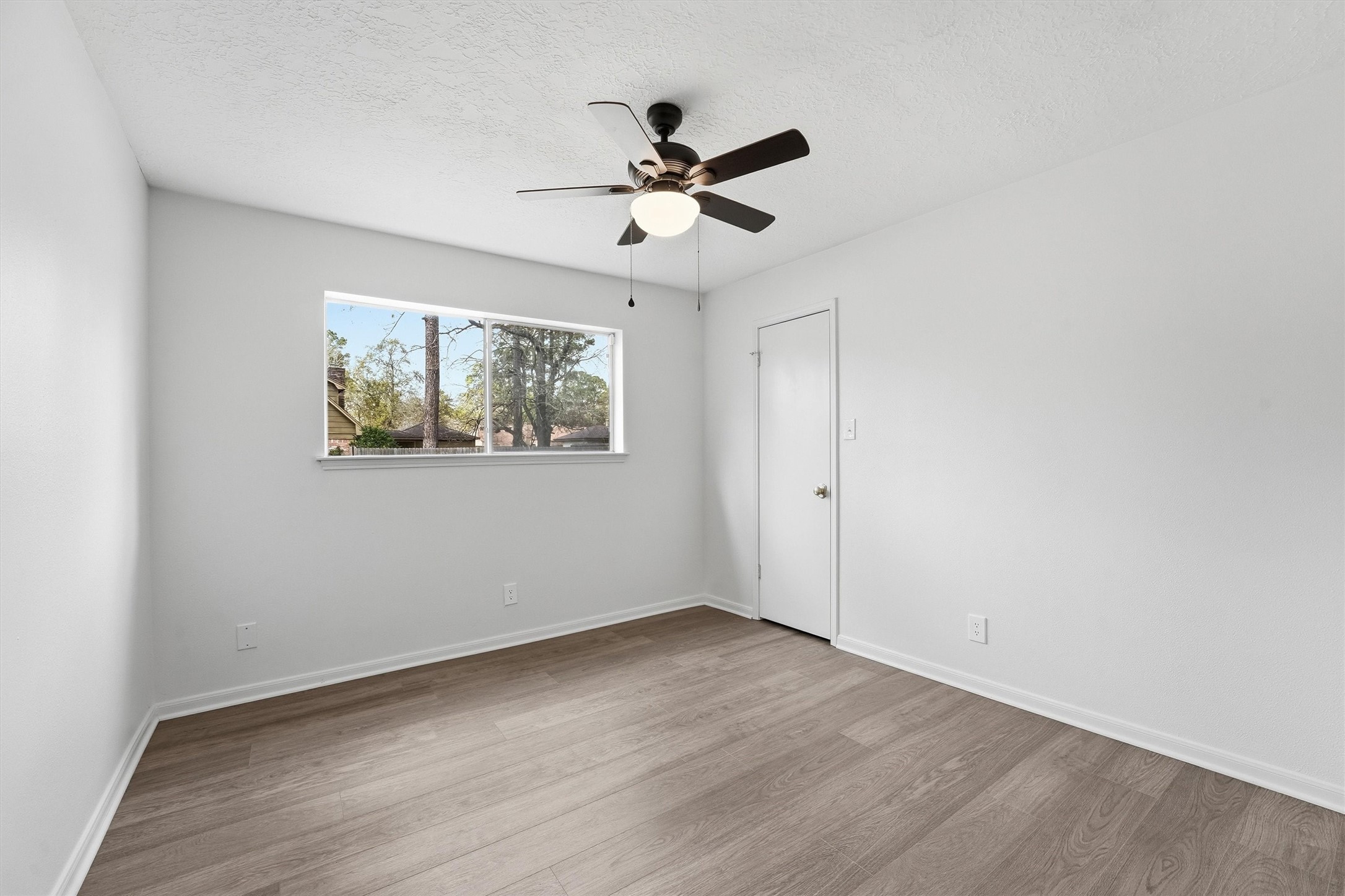 2203 Rolling Meadows Drive Houston, TX 77339 - Photo 20 of 27 an empty room with wooden floor ceiling fan and windows