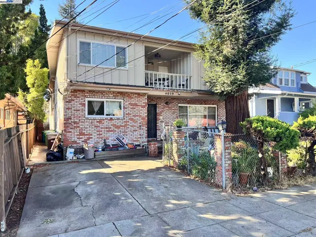 a view of a house with brick walls and a yard with plants