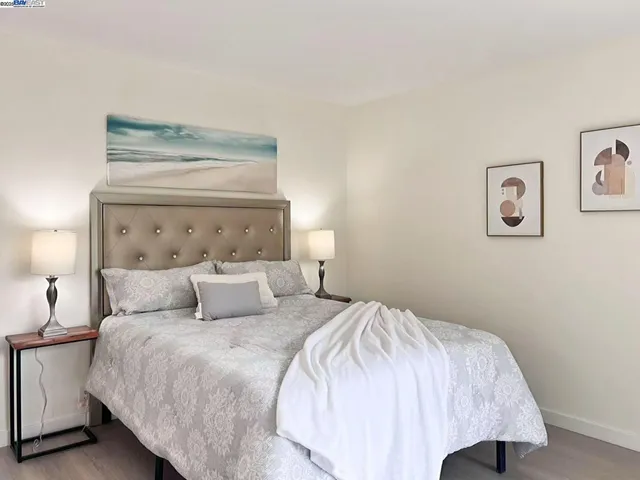 a bedroom with a bed and painting on the wall