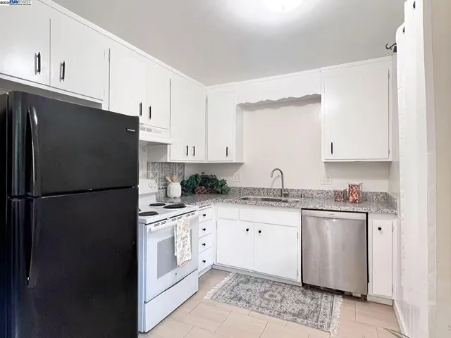 a kitchen with granite countertop cabinets and refrigerator