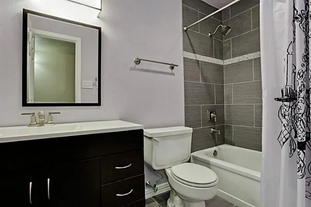 a bathroom with a sink toilet vanity and shower