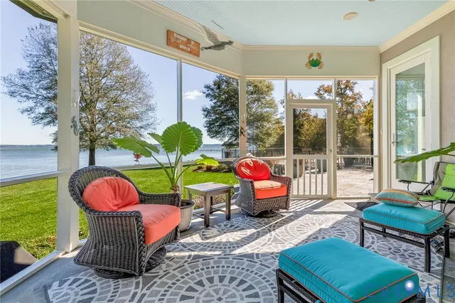 a living room filled with furniture and floor to ceiling windows