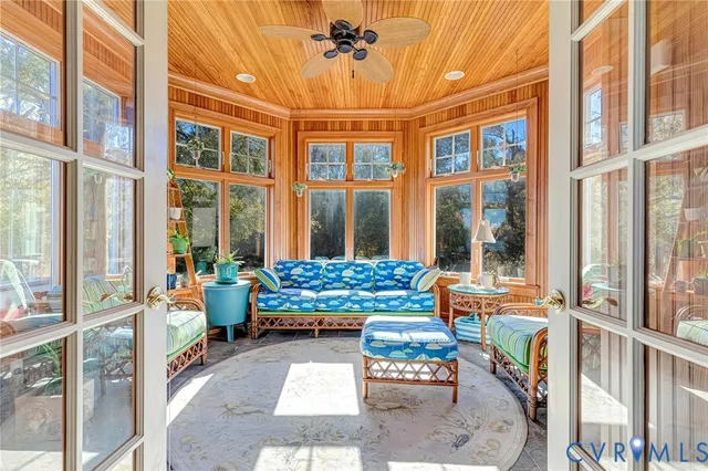 a living room filled with furniture and floor to ceiling windows