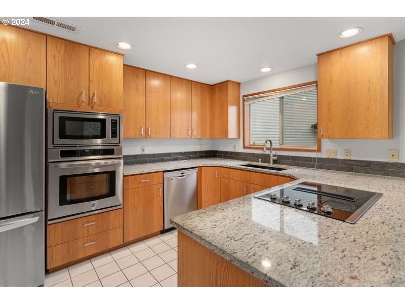 15917 Northeast Union Road, Unit 102 Ridgefield, WA 98642 - Photo 7 of 29 a kitchen with stainless steel appliances granite countertop a sink a microwave a stove and refrigerator