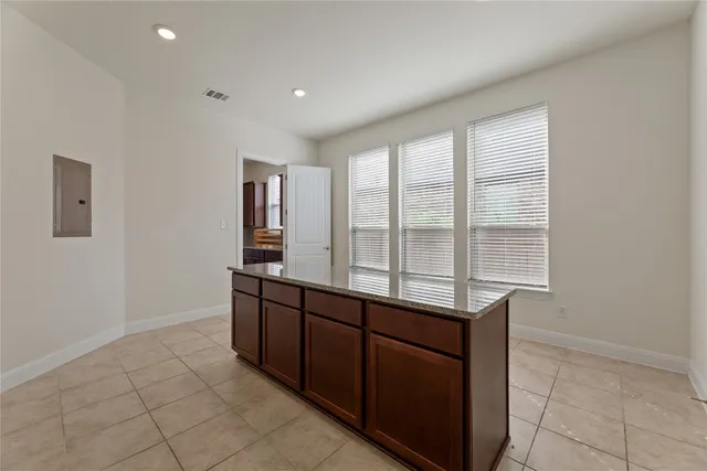 a kitchen with wooden cabinets and window