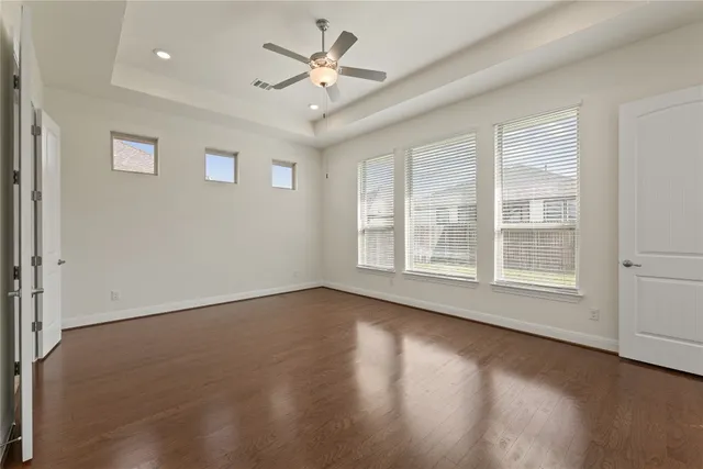 a view of an empty room with a window and wooden floor