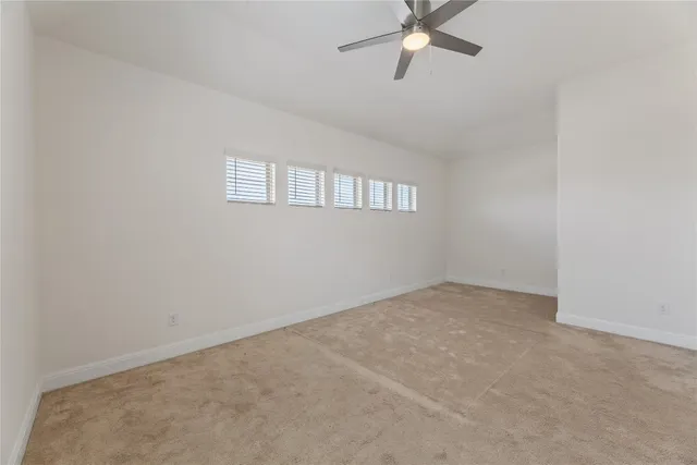an empty room with a window and a fan