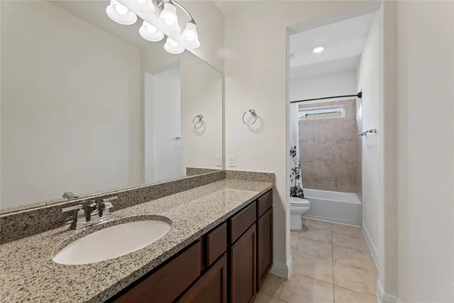 a bathroom with a granite countertop sink a toilet and a mirror