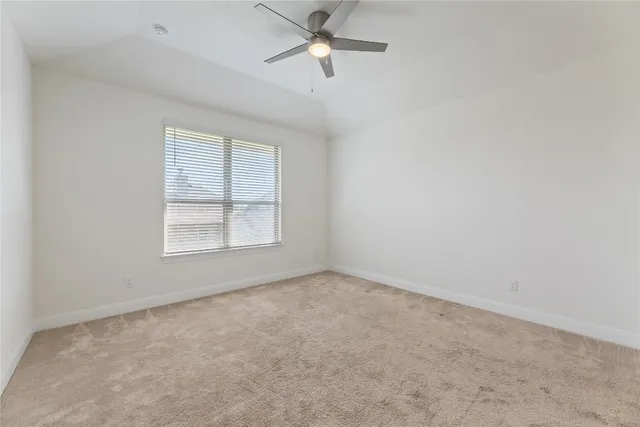 an empty room with a window and a ceiling fan
